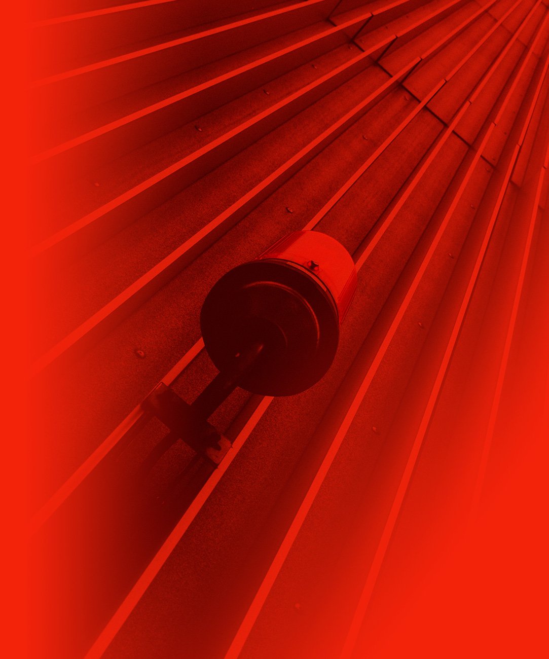 Emergency alarm light hanging off wall in red filter